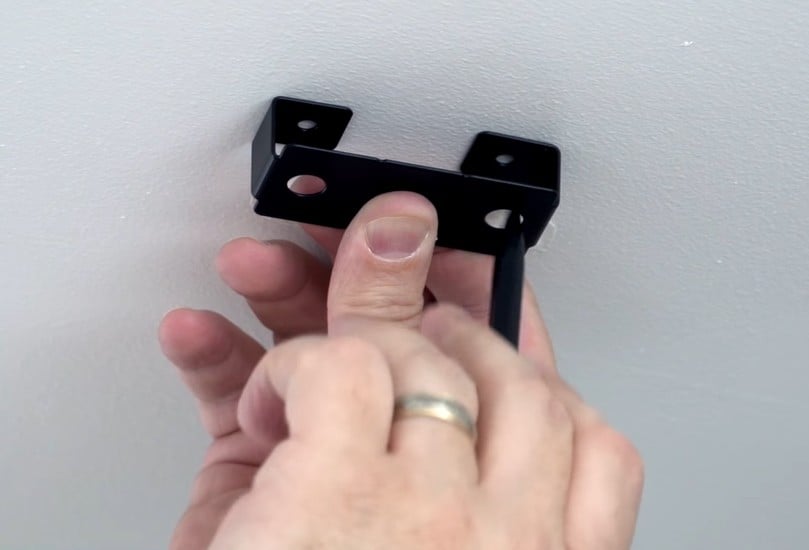 Mark the spot on the ceiling using the holes in the mounting bracket as a guide